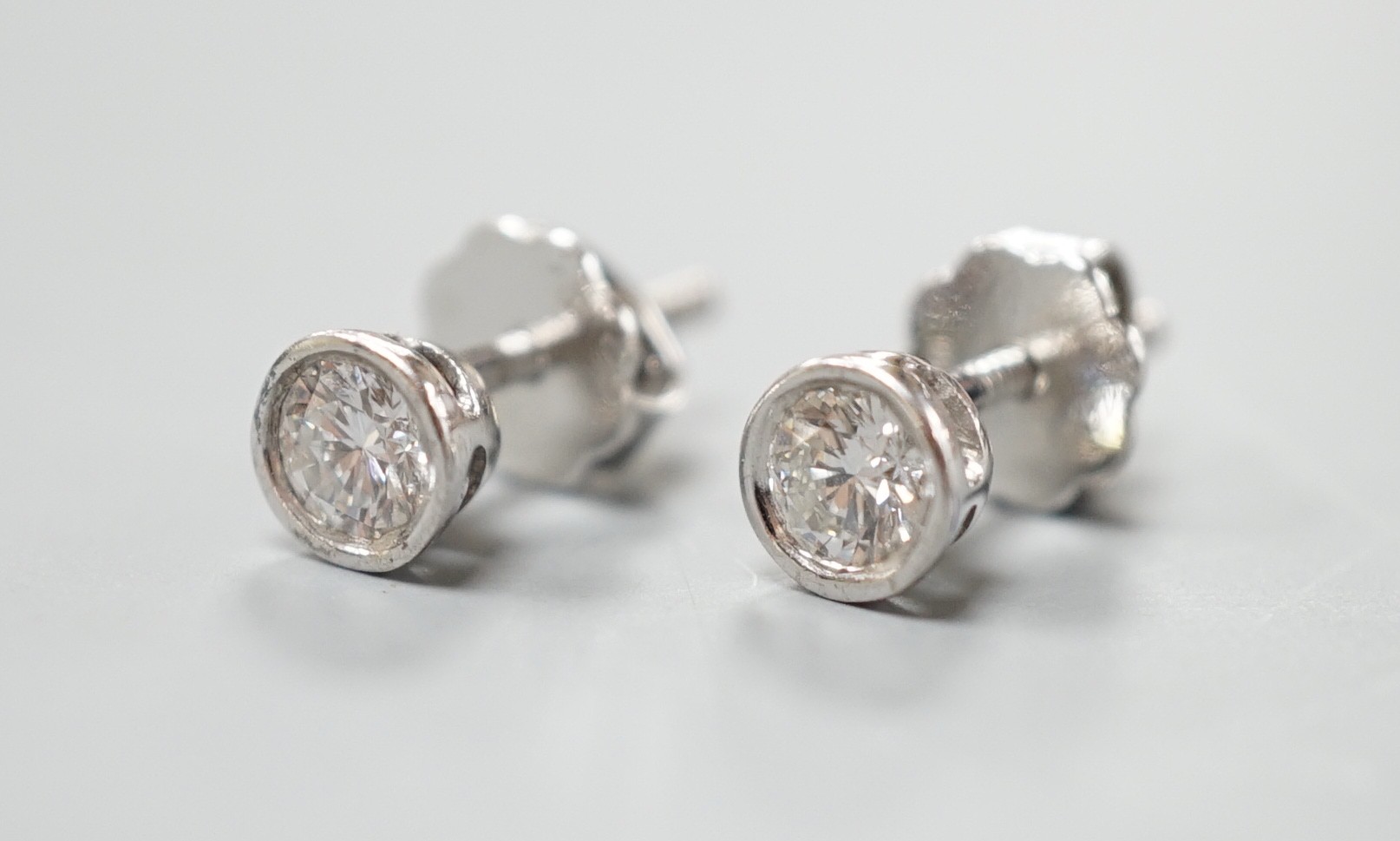 A pair of 750 white metal and collet set solitaire diamond ear studs, gross weight 1.5 grams, stone diameter approx. 3.7mm.